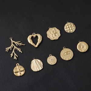 Détail de neuf pendentifs assortis en acier inoxydable doré aux motifs géométriques