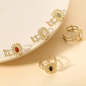 Dettaglio di anelli vintage a girasole dorati con pietre ovali e fasce decorate
