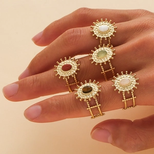 Set di 5 anelli a girasole dorati con pietre ovali colorate indossati su una mano