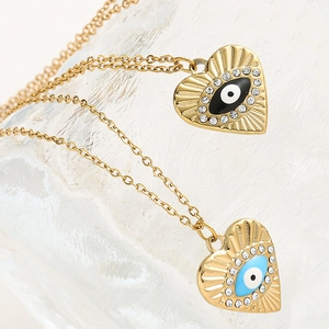 Vue macro des pendentifs cœur œil bleu et noir avec émail et finition dorée