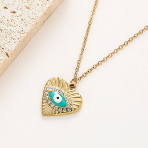 Détail macro du pendentif coeur mauvais oeil doré avec cristaux de zircone micro-incrustés