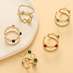 Dettaglio di set di 5 anelli boho dorati con pietre turchesi e motivo a rombi cavi