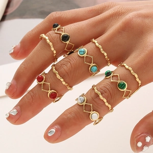 Dettaglio del set di 5 anelli dorati boho con turchese e pietre colorate miste