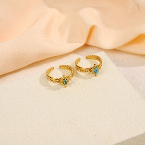 Close-up of gold twist rings featuring natural green and turquoise stones on display
