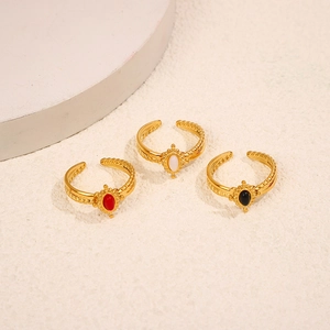 Detail of gold oval natural stone rings with twisted band and adjustable open design