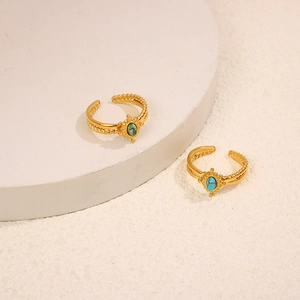 Detail of gold twisted band rings with oval green stone and turquoise insets