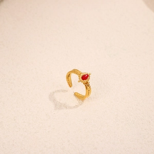 Macro shot of oval red gemstone ring with twisted gold band and vintage detailing