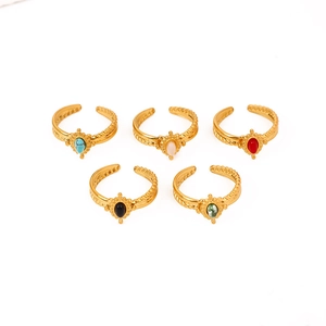Detail of vintage gold-plated rings set with colorful oval stones and twisted bands