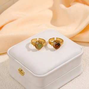 Macro view of vintage gold-plated rings with green and tiger eye stone inlay detail