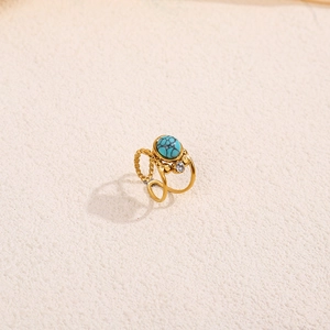 Detail of vintage gold ring featuring a turquoise stone and delicate twisted band texture