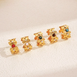 Five gold flower rings with colorful gemstones and small crystals in a diagonal display