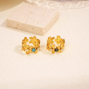 Close-up of 18k gold plated hollow flower rings with blue and green gemstone inlay