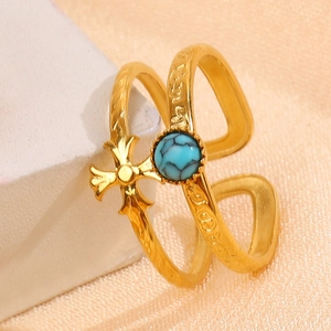 Detail of 18K gold double-layer cross ring with turquoise stone and gothic engraving