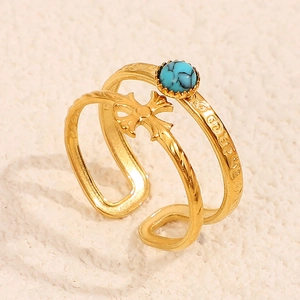 Close-up of gothic cross ring with turquoise stone and 18K gold plated engraving