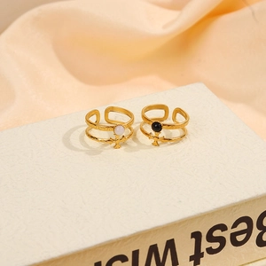 Detail of 18K gold-plated double-layer rings with cross charms and black and white beads