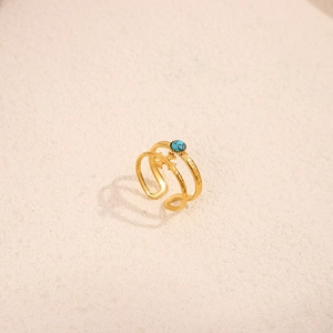 Detail of 18K gold stainless steel double-layer ring with turquoise stone and cross charm