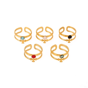 Detailed macro view of 18K gold plated stackable rings set with colorful gemstone crosses