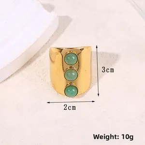 Close-up of vintage wide gold ring featuring three green stones and 2x3cm size detail