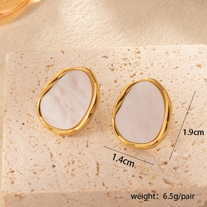 Detailed view of pebble-shaped gold earrings with white pearlescent inlay and size specs
