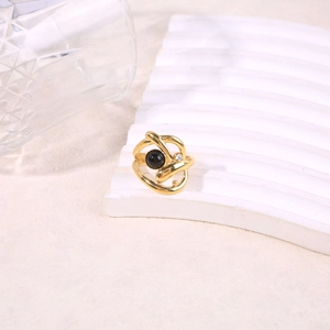 Detail of gold layered twist ring featuring black onyx gemstone and small zircon accent