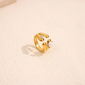 Detail of vintage gold-plated titanium ring with white natural stone and zircon