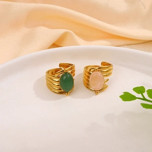 Detailed shot of gold plated textured rings with green and pink natural stones
