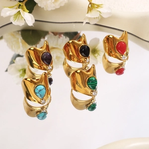 Detailed view of vintage gold-plated wide rings featuring colorful teardrop-shaped gemstones