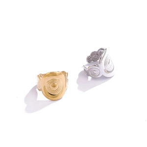 Close-up of geometric spiral wave textured stainless steel rings in gold and silver
