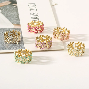 Detailed macro view of six colorful enamel leaf rings with golden metal bases