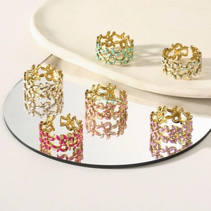 Detail of colorful enamel flower rings with adjustable hollow design on mirror surface