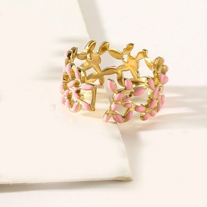 Detail of gold stainless steel ring with leaf shapes and pink enamel fill