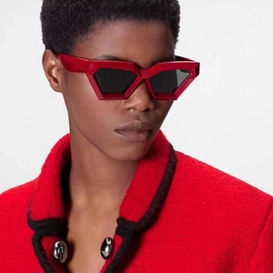 Macro shot of futuristic red geometric sunglasses with dark lenses on a model
