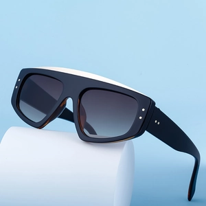 Lunettes de soleil à dessus plat avec monture noir et blanc sur fond bleu