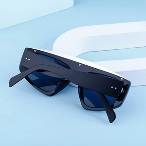 Détail de lunettes de soleil noires à petites montures avec clous argentés