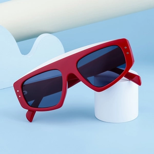 Détail de lunettes de soleil œil-de-chat rouges avec rivets sur plateforme