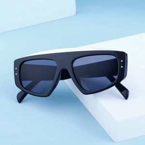 Détail de lunettes de soleil carrées noires avec verres bleus et rivets argentés