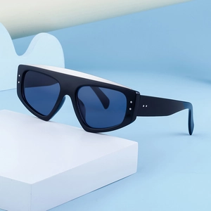 Détail de lunettes de soleil œil-de-chat noires avec accents argentés et verres bleus