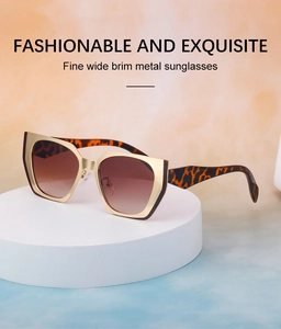 Detail view of cat eye sunglasses with golden metal frame and leopard print temples