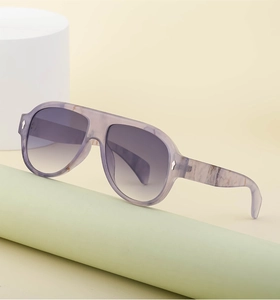Detail of pilot sunglasses with purple marble frame and gradient lenses on props