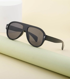 Detail of matte black pilot sunglasses with silver diamond metal rivets on the frame