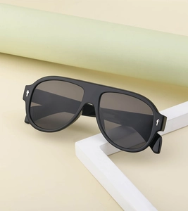 Detail of black aviator sunglasses frame featuring silver arrow metal accents on the temple