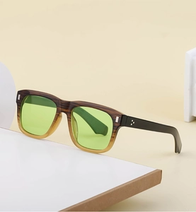 Detail view of square wooden grain sunglasses with translucent green lenses and silver rivets