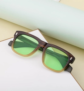 Detail of square gradient frame sunglasses with wood grain texture and green lenses