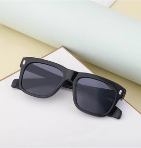 Close-up of square sunglasses frame with silver metal accents and gray lenses