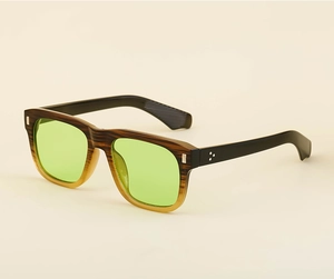 Detail of wood grain texture sunglasses frame with green lenses and silver rivets