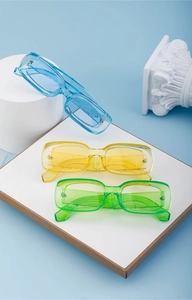 Close-up of rectangular jelly sunglasses in blue, yellow, and green on display stands