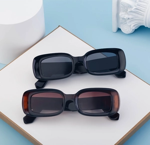 Detail of stylish rectangle sunglasses in black and tortoise on a minimalist prop set