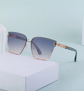 Detail of oversized nylon sunglasses featuring hollow chain metal temples on stone pedestal