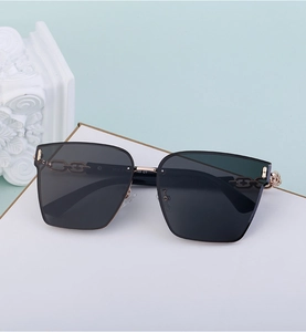 Detailed view of square oversized sunglasses with gold chain temples and gray UV400 lenses