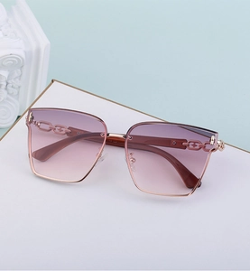 Macro shot of oversized nylon sunglasses featuring gradient purple lenses and chain temples